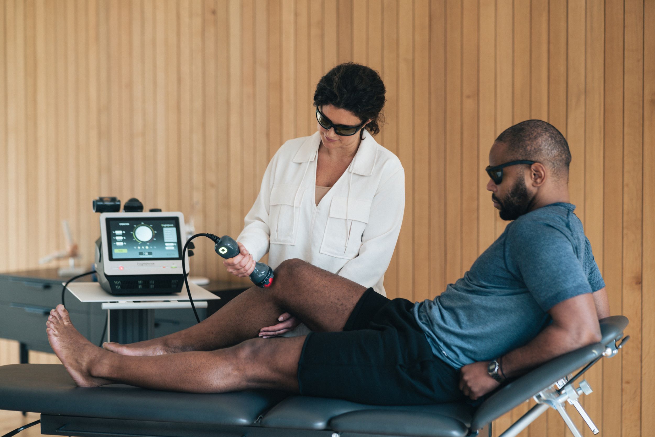 clinician using laser on patient knee