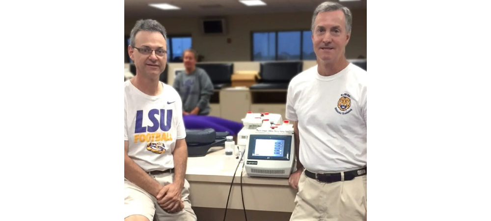 two men standing with laser module between them
