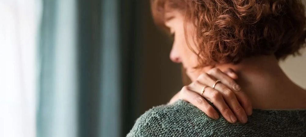woman rubbing her shoulder