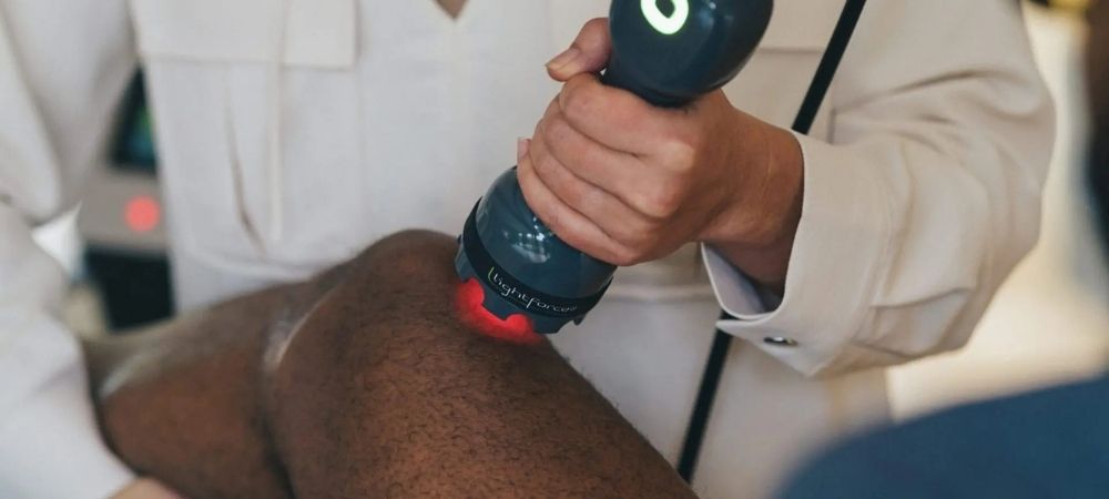 clinician applying laser to knee