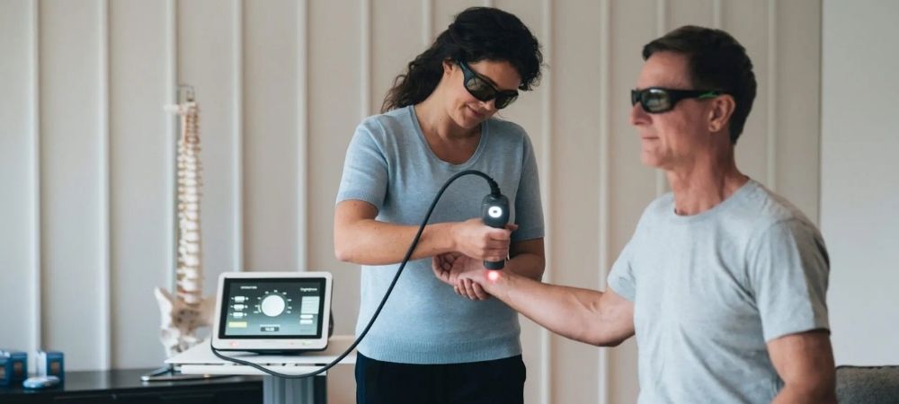 clinician applying laser to patient wrist